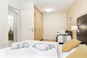 a white bedroom with two pillows on a bed at Ponent 602 in Marina Portorož by Locap Group in Portorož