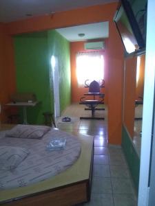 a bedroom with green and orange walls and a bed at Motel livistar in São Paulo