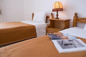 een kamer met twee bedden en een boek op een tafel bij Soula Apartments in Ýpsos +12 foto's