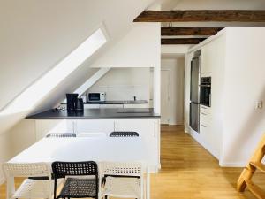 a white kitchen with a table and chairs at aday - City Central Mansion - 4 bedroom apartment in Aalborg