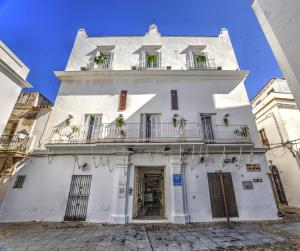 un bâtiment blanc avec des plantes sur les balcons dans l'établissement La Casa de la Favorita, à Tarifa