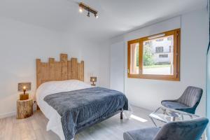 1 dormitorio con 1 cama, 1 silla y 1 ventana en Chalet Aravis, en Flumet
