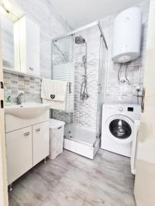 y baño con lavadora y ducha. en CALLA - Modern & Cozy Main Square Apartment in the City Shopping Center - PARKING SLOT with parking security, en Skopje