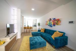 un salon avec un canapé bleu et une télévision dans l'établissement FERREIRA'S HOUSE Guimarães, à Guimarães