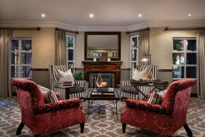 a living room with two chairs and a fireplace at Premier Hotel Quatermain in Johannesburg