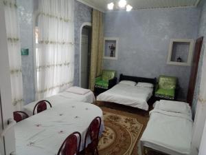 Habitación con 2 camas y 2 sillas. en Ilgar's Hostel, en Sheki