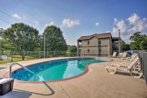 a swimming pool with chairs and a house at Branson West Villa w/ Golf Course View & Pool! in Branson West