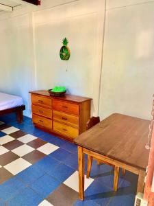 a room with a wooden table and a dresser at Casa Nara in Puerto Viejo