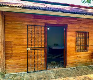 una porta aperta su una casa in legno con un letto di Casa Nara a Puerto Viejo