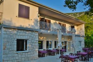 eine Terrasse mit lila Tischen und Stühlen vor einem Gebäude in der Unterkunft Apartment Jure in Senj