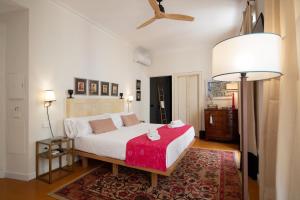 um quarto com uma cama branca e um cobertor vermelho em MDD4 Health Experience Hotel - Adults Only em Sevilha