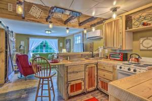 una cocina con armarios de madera, mesa y sillas en The Country Cottage in Union Mills with Porch! en Union Mills