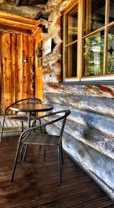 two tables and chairs on a porch of a log cabin at Ruka Chalet Charmant Oliver in Ruka