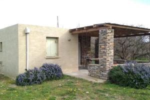 a house with a stone pillar and a porch at Cottage amidst vines and Oak Trees in Ioulis