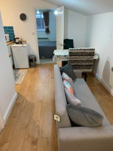 a living room with a couch and wooden floors at Comfy New Self Contained 1 Bed Flat - Modern! in Draycott