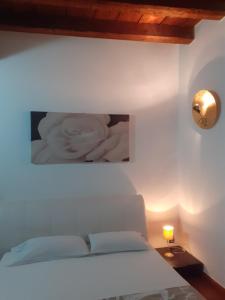 Un dormitorio con una cama blanca y una foto en la pared en La Corte Dei Cappuccini en Bergamo