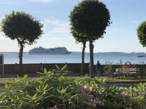 a cruise ship in the water with trees and flowers at Fördekoje in Laboe