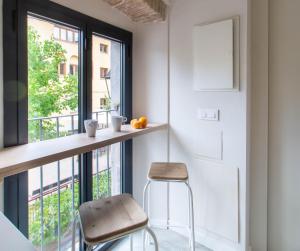 a kitchen with a counter and a stool next to a window at Aeris Boutique Studio in Girona
