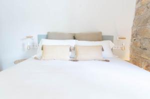 a bedroom with a bed with white sheets and pillows at Aeris Boutique Studio in Girona