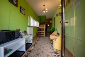 ein Wohnzimmer mit grünen Wänden und einer Treppe in der Unterkunft Bajeczny Wypoczynek Apartamenty in Witów