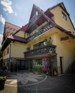 a building with a patio in front of it at Bajeczny Wypoczynek Apartamenty in Witów