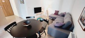 a living room with a table and a couch at Central Apartments Ogrody 2 & Parking in Gdańsk