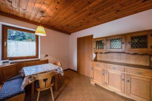 een keuken met een tafel en een aantal houten kasten bij Grödnerhof Peter in Tires