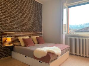 sypialnia z łóżkiem i ścianą z cegły w obiekcie Camozzi Central Apartment w Bergamo