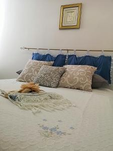 Una cama con almohadas azules y una manta. en A Casa di Santé, en Arnesano