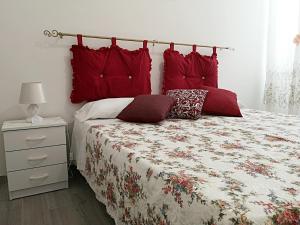 a bedroom with a bed with red pillows on it at A Casa di Santé in Arnesano