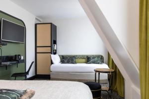 Cette chambre comprend un lit et une télévision. dans l'établissement Grand Hotel Chicago, à Paris