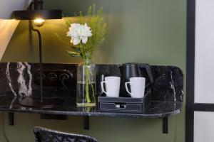 パリにあるGrand Hotel Chicagoの花瓶とカップが飾られた黒いテーブル
