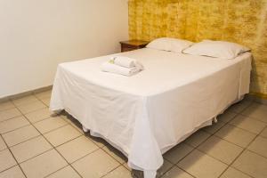 Una cama blanca con dos toallas encima. en Pousada Recanto da Serra, en Serra do Cipo