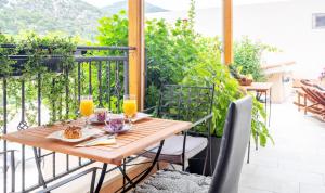una mesa de madera en un balcón con copas de zumo de naranja en Apartments Ante, en Hvar