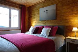 sypialnia z dużym łóżkiem z czerwoną pościelą w obiekcie Le Chalet de Hermeton w mieście Hastière-par-delà