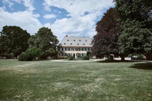 ein großes weißes Haus mit einem großen Rasenhof in der Unterkunft Gutshotel Baron Knyphausen in Eltville