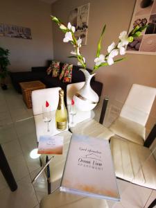a table with a bottle of wine and a vase with flowers at Ocean View Apartment in Adeje