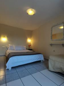 a bedroom with a large bed and a mirror at Sea waves apartments in Néa Epídhavros