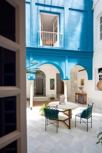 Zimmer in einem blauen Gebäude mit einem Tisch und Stühlen in der Unterkunft MDD4 Health Experience Hotel - Adults Only in Sevilla
