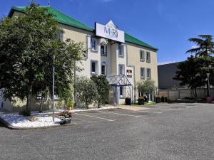 un hôtel avec un panneau sur le côté d'un bâtiment dans l'établissement Hôtel M&R, à Ifs