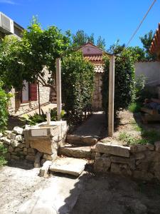 einen Garten mit einem Steinzaun und einer Steinmauer in der Unterkunft Vila Flora in Susak