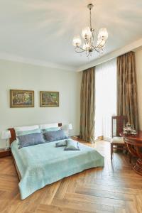 a bedroom with a large bed and a chandelier at Pałac w Smoszewie in Smoszewo
