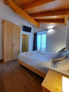 een slaapkamer met een groot bed en een raam bij B&B alla Spiazzőla in Spormaggiore