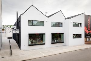 a white building with black windows on the side of it at RASL House in Luka nad Jihlavou