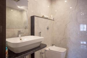Un baño blanco con lavabo e inodoro. en Hotel Hari Vilaas, en Varanasi
