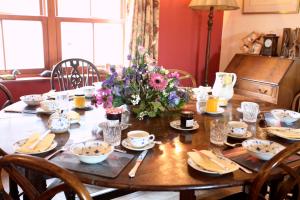 a wooden table with a vase of flowers on it at Knockaloe Beg Farm in Patrick +23 photos