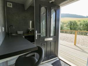 アベリストウィスにあるCaban Glasのキッチン(カウンター付)、バルコニー付きのドアが備わります。