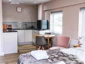 a kitchen with a table and chairs in a room at Lindens Annexe in Shrewsbury