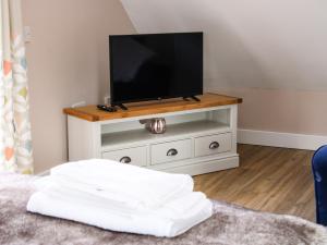 a tv sitting on a white cabinet with a television at Lindens Annexe in Shrewsbury