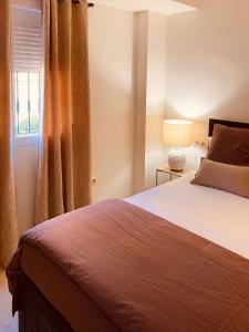 ein Schlafzimmer mit einem Bett und einem Fenster in der Unterkunft Lagos de Santa María Luxury Apartment Isabel in Marbella